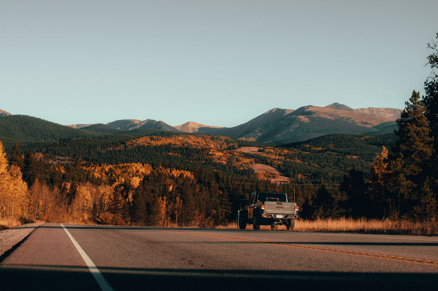 A 4x4 truck road trip through scenic autumn mountain landscape, ideal for adventure seekers.